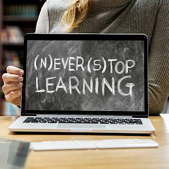 Laptop mit Aufschrift: (N)EVER (S)TOP LEARNING