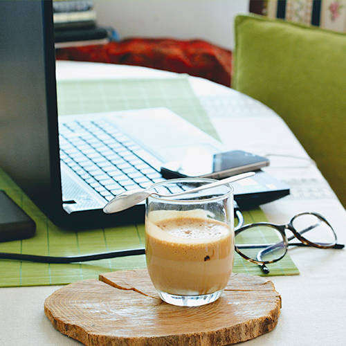 Laptop auf Wonhzimmertisch mit Getränk