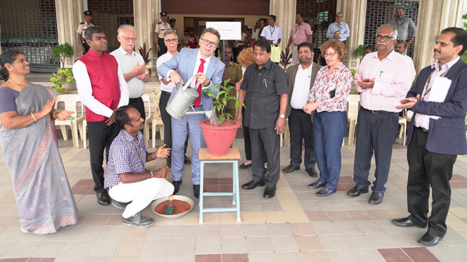 Prof. Dr. Volker Epping gießt eine Blume, umringt von der Delegation und den indischen Gastgeberinnen und Gastgebern