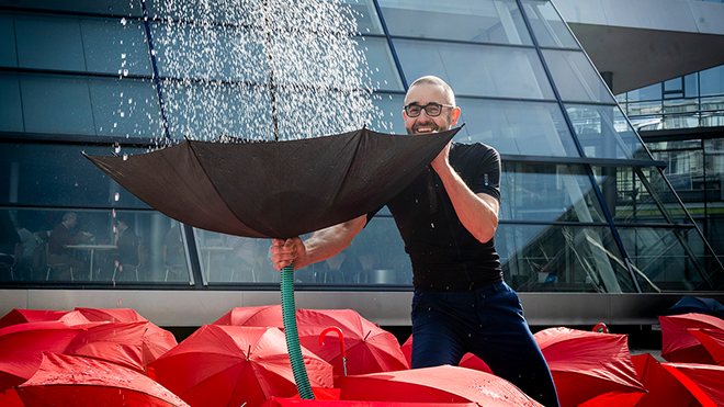 Prof. Dr. Stephan Köster fängt mit einem Regenschirm Wasser auf